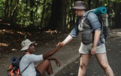 hiker holding hand of black friend on road