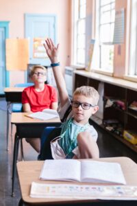 boy raising his hand in the classroom