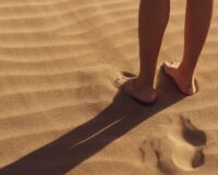 person stand on sand